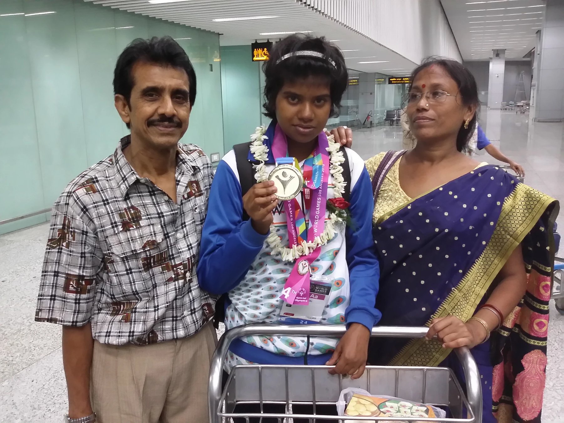 Supriya Saha with her parents at Kolkata airport, holding her Special Olympics gold medal